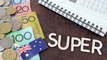Australia currency, coins and flag with a notebook and calculator and the word "Super" in between the notebook and the money..