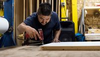 A worker builds the interior cabinetry for a recreational vehicle at the HL Enterprise manufacturing facility in Elkhart, Ind., on Oct. 8, 2020